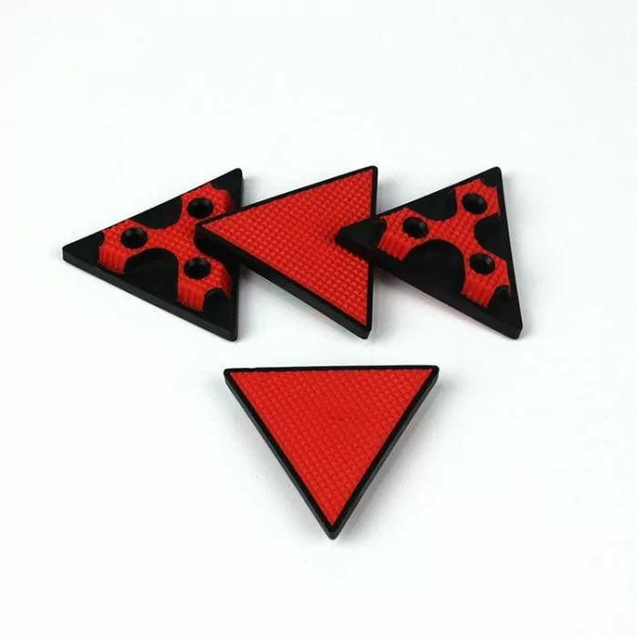 Set of red and black non-slip triangular woodworker bench dogs on white background