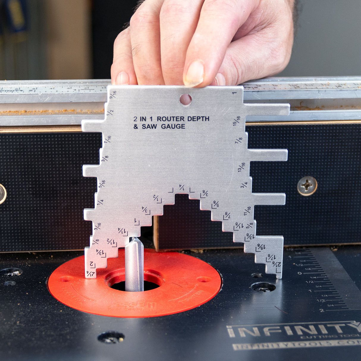 Hand using 2-in-1 router depth and saw gauge to measure router bit height on table