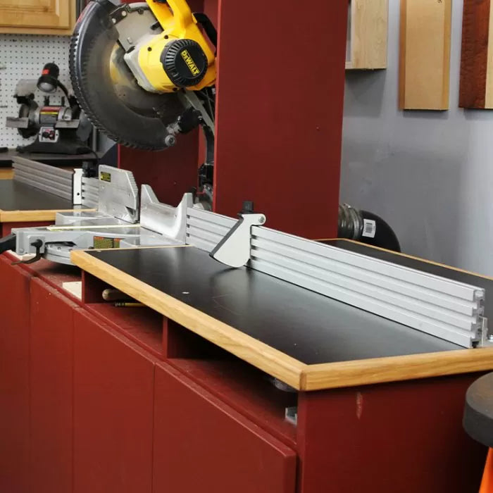 Woodworking miter saw station with aluminum fence and stop block system in a workshop