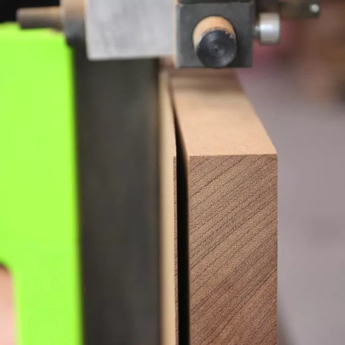 Close-up of a bandsaw blade cutting a straight line through a hardwood board