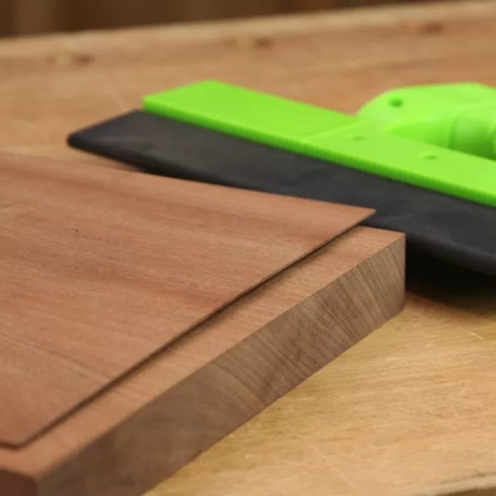 Push block smoothing wood board on workbench, woodworking safety tool in use