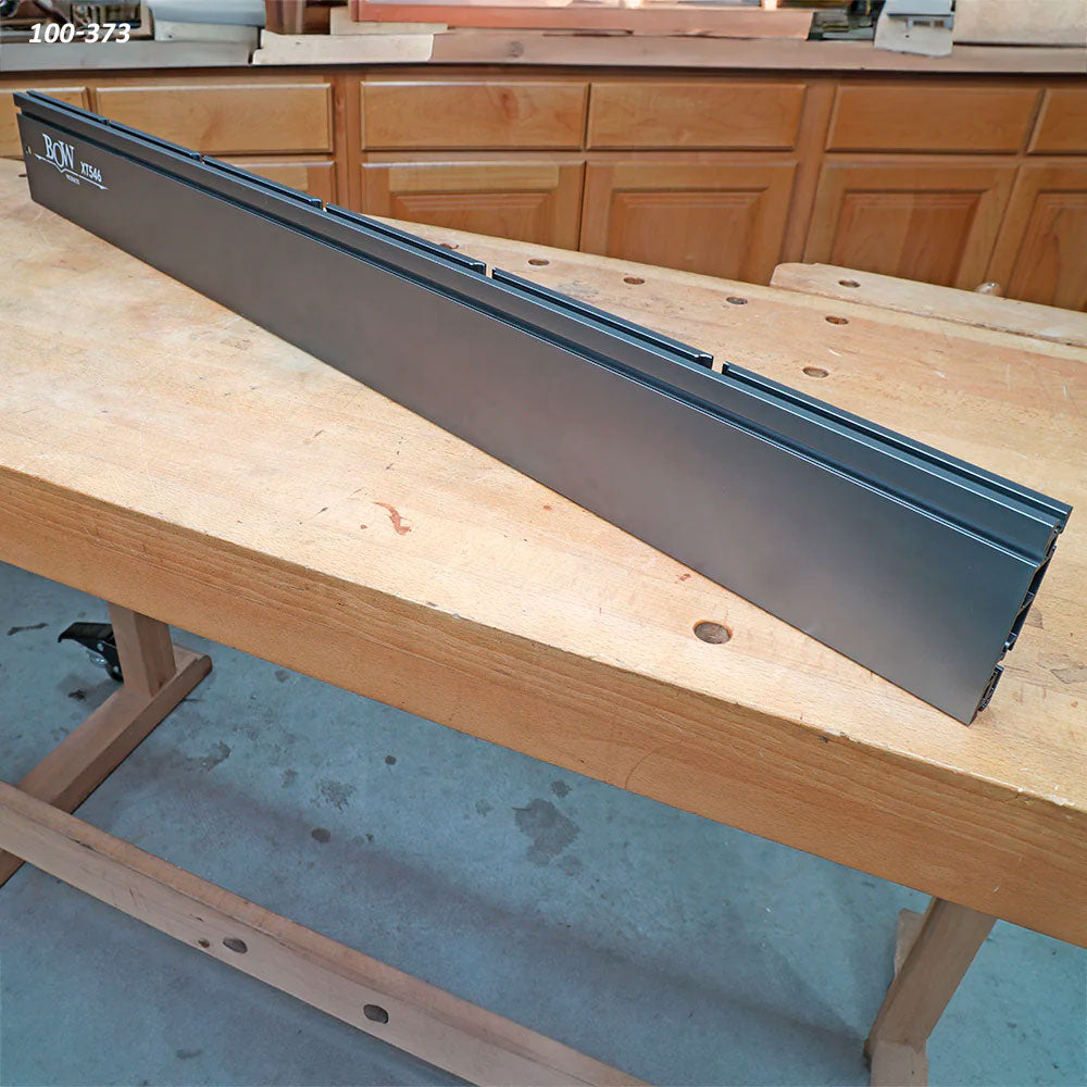 Aluminum table saw fence on woodworking bench in workshop setting