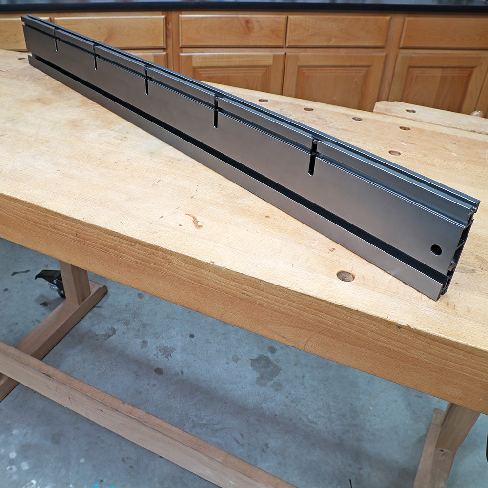 Aluminum router table fence with T-slots on a wooden workbench in a workshop setting