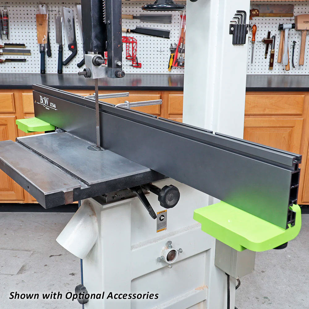 Woodworking bandsaw with precision fence and green accessory supports in workshop setting