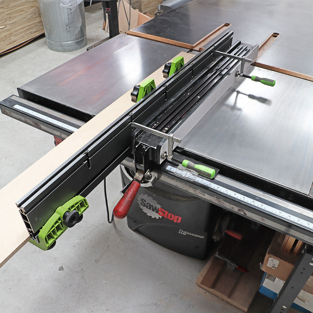 Table saw with precision fence, push block, and measuring gauge for woodworking.