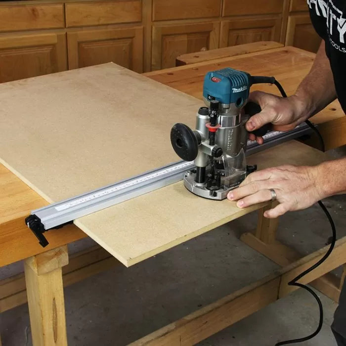 Woodworker using a router and guide rail to cut MDF board on a workbench