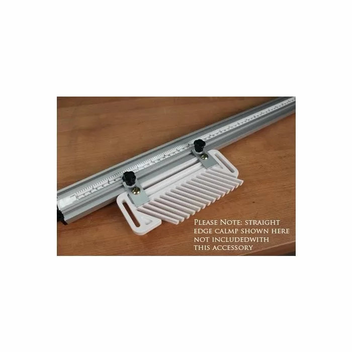 Featherboard woodworking accessory attached to a metal guide rail on a wooden surface