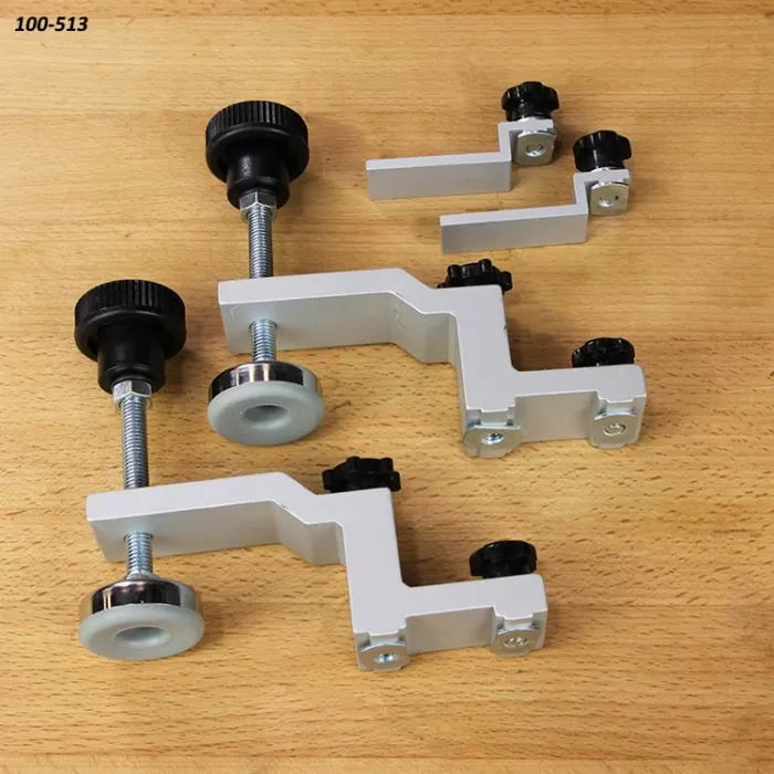 Set of adjustable woodworking hold-down clamps on a wooden workbench surface
