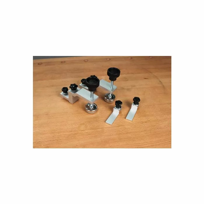 Woodworking jig hardware set with aluminum brackets and black knobs on a workbench
