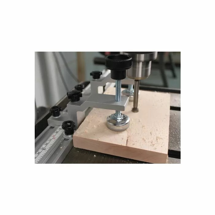 Drill press with hold-down clamp securing wood for precise woodworking drilling