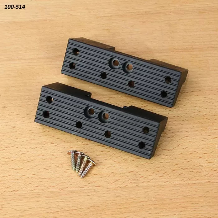 Set of two black plastic woodworking jig blocks with screws on wood surface