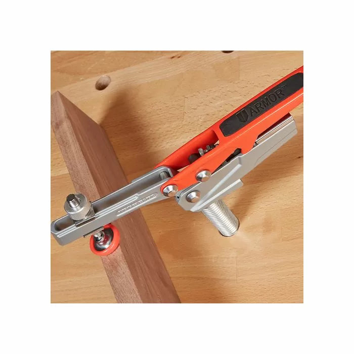Toggle clamp securing wooden board on workbench for woodworking projects