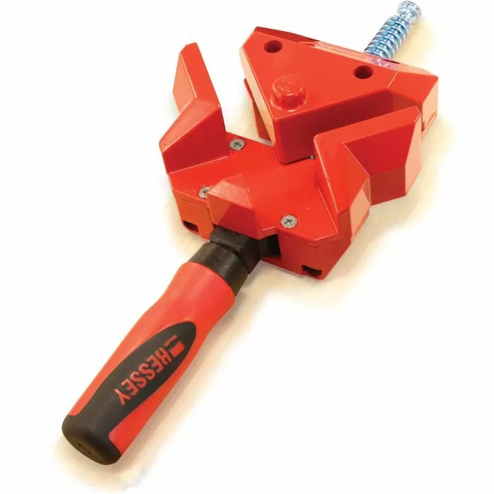 Red adjustable woodworking corner clamp with ergonomic handle on white background