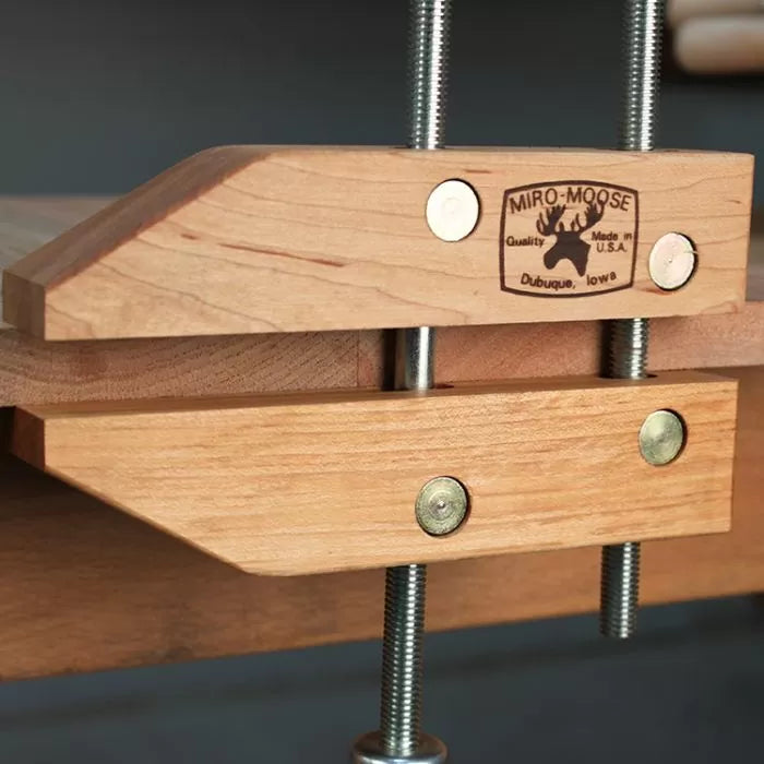 Woodworking hand screw clamp with metal bolts securing wooden jaws for precise clamping