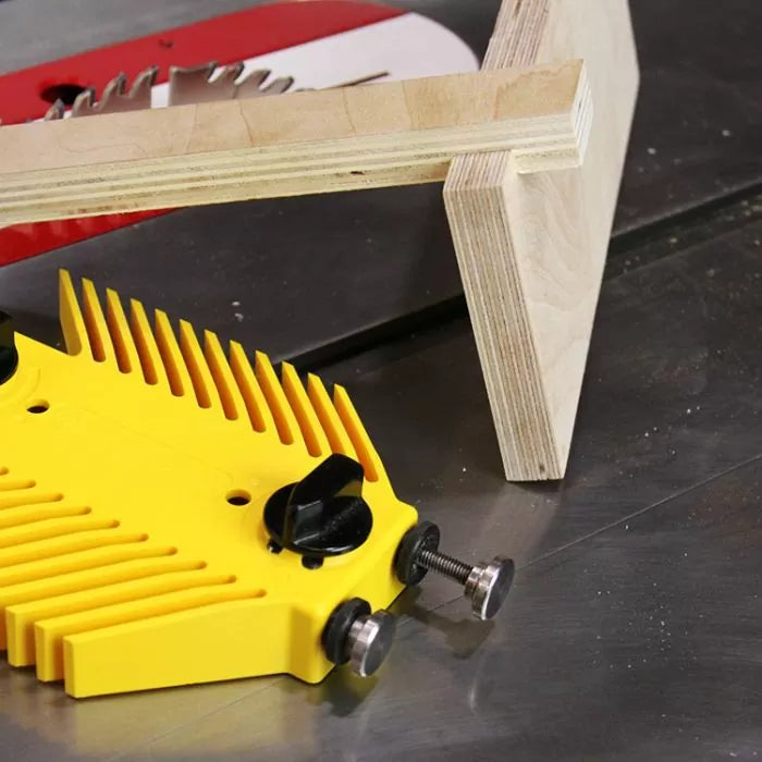 Yellow featherboard and wood on table saw for woodworking precision