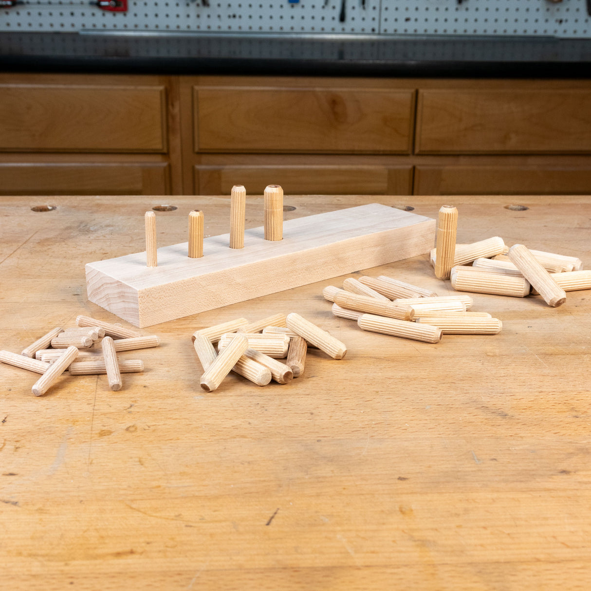 Wooden pegs and a wooden block on a wooden table with a workshop background
