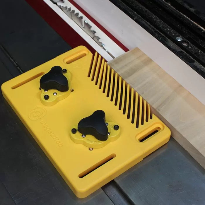 Yellow magnetic featherboard holding wood against table saw fence for precise cutting