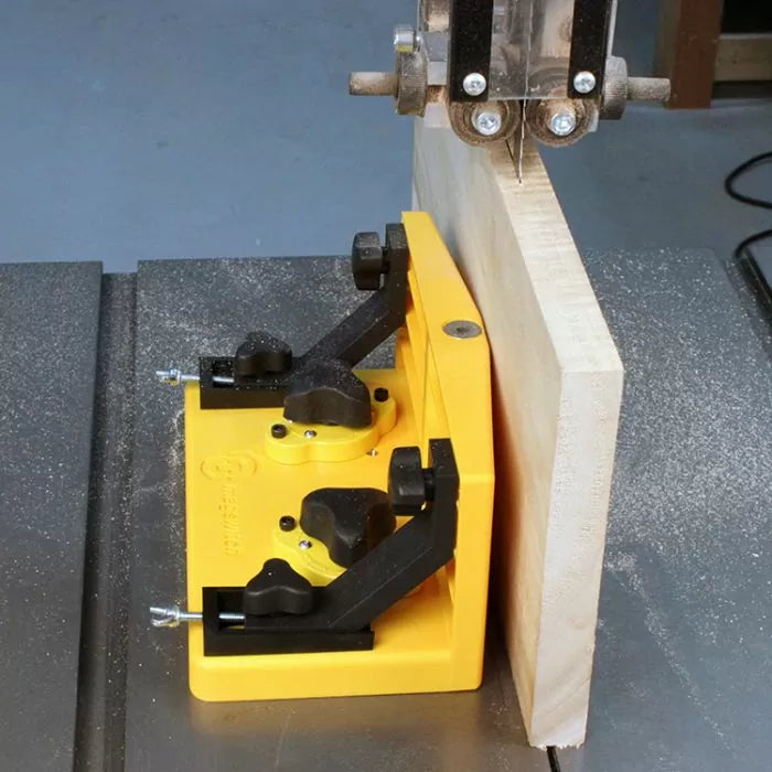 Yellow band saw fence jig holding wood board for precise straight cutting