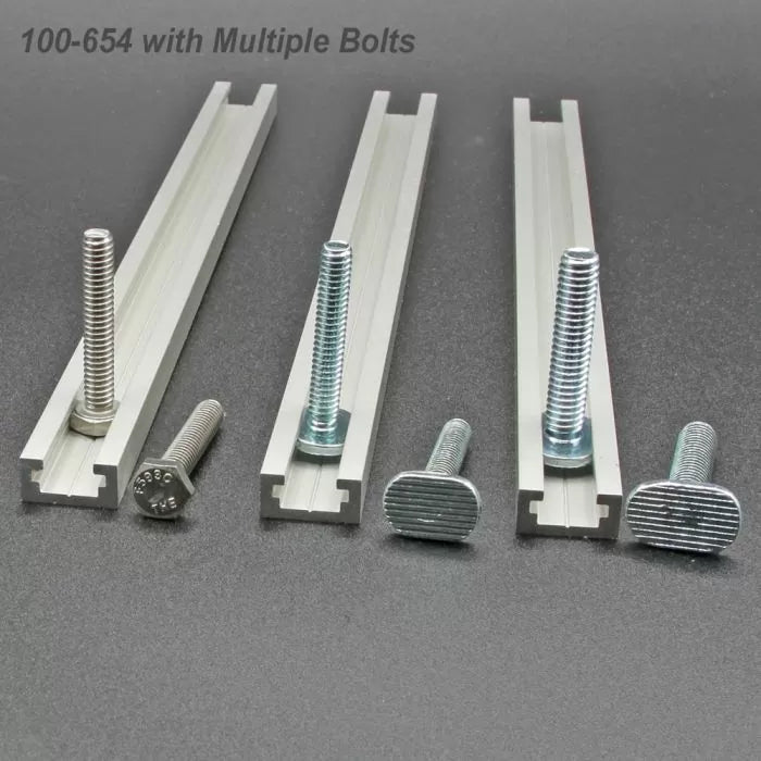 Three T-tracks with assorted bolts for woodworking jigs and fixtures on a gray surface.