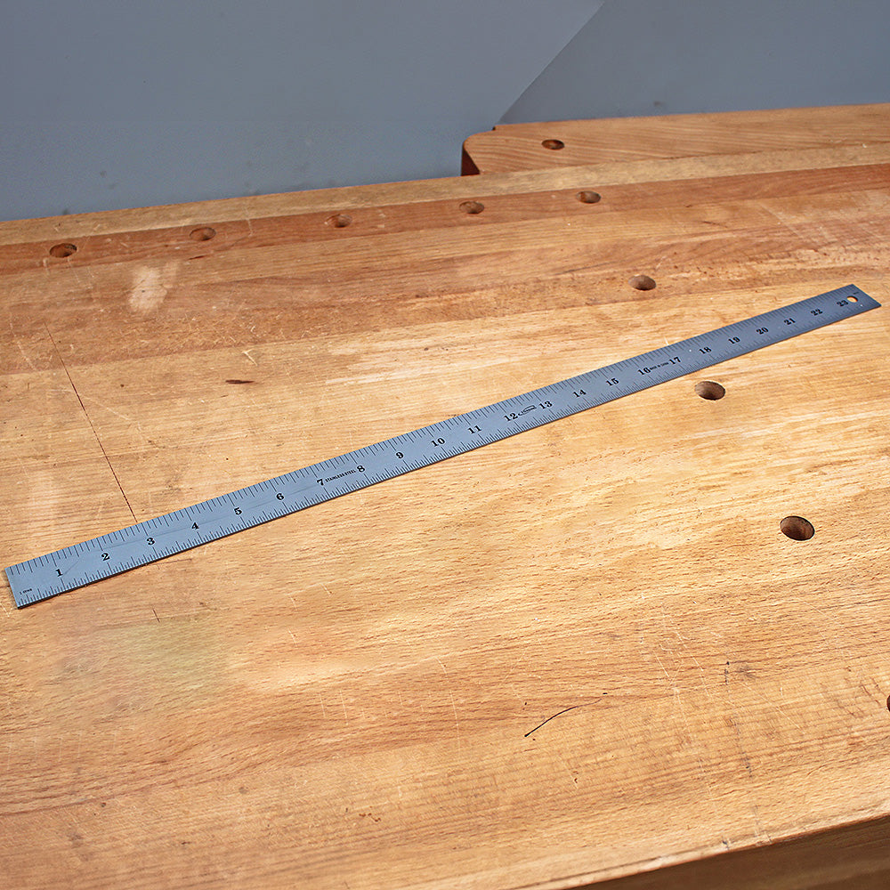 Steel metric ruler on a wooden workbench, ideal for woodworking measurement and layout