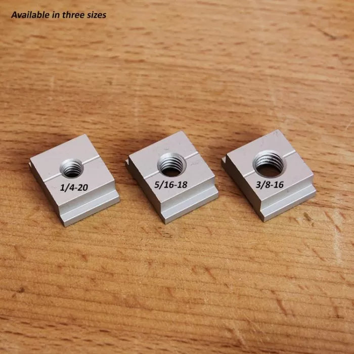 Three T-track nuts in 1/4-20, 5/16-18, 3/8-16 sizes on a wooden surface