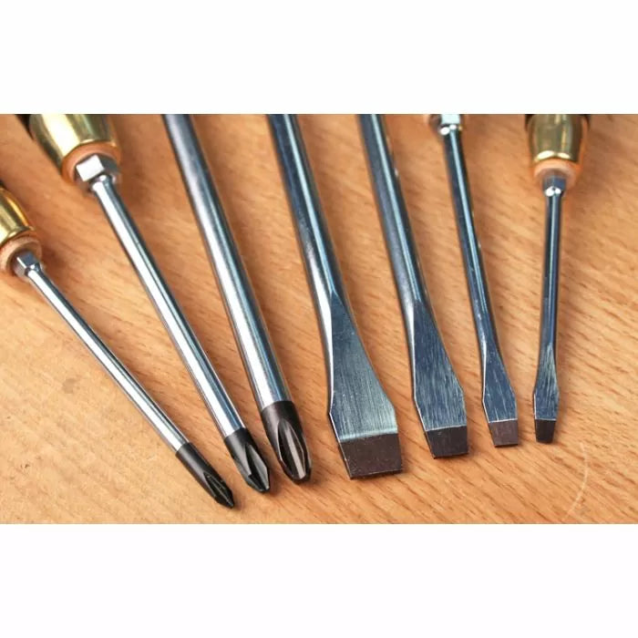 Assorted flathead and Phillips screwdrivers on a wood surface, woodworking hand tools