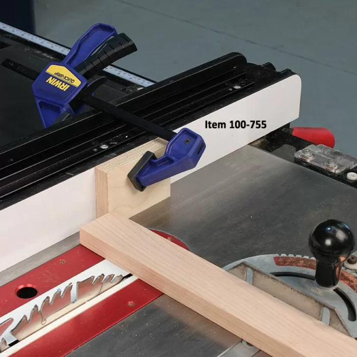 L-shaped woodworking jig clamped to table saw fence for precise cutting setup