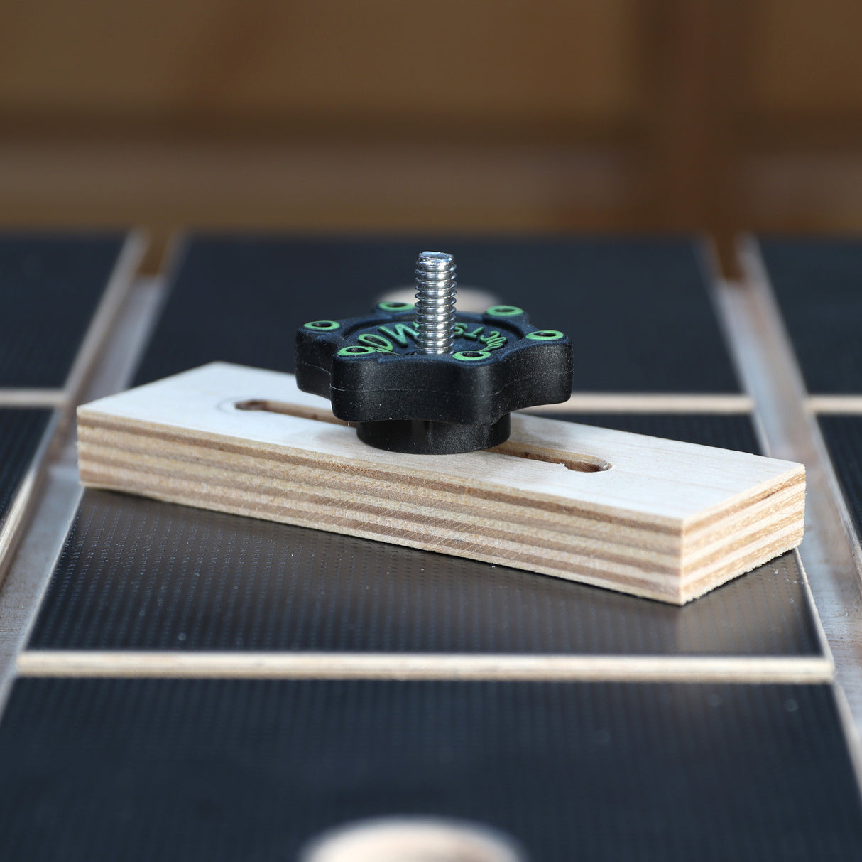 Woodworking T-track hold down clamp with knob on workshop table