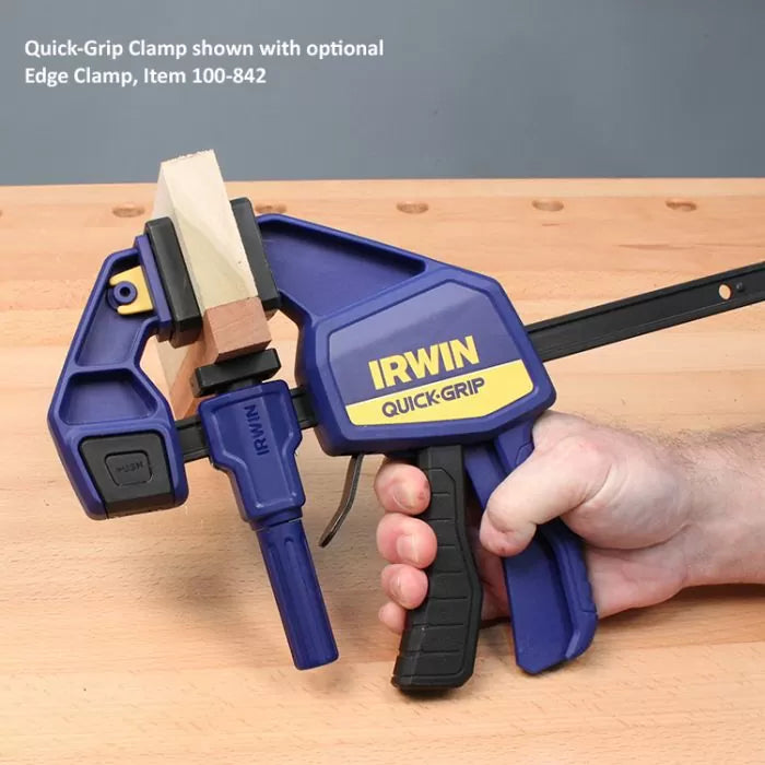 Quick-Grip clamp with edge clamp attachment securing wood on a workbench, woodworking tool