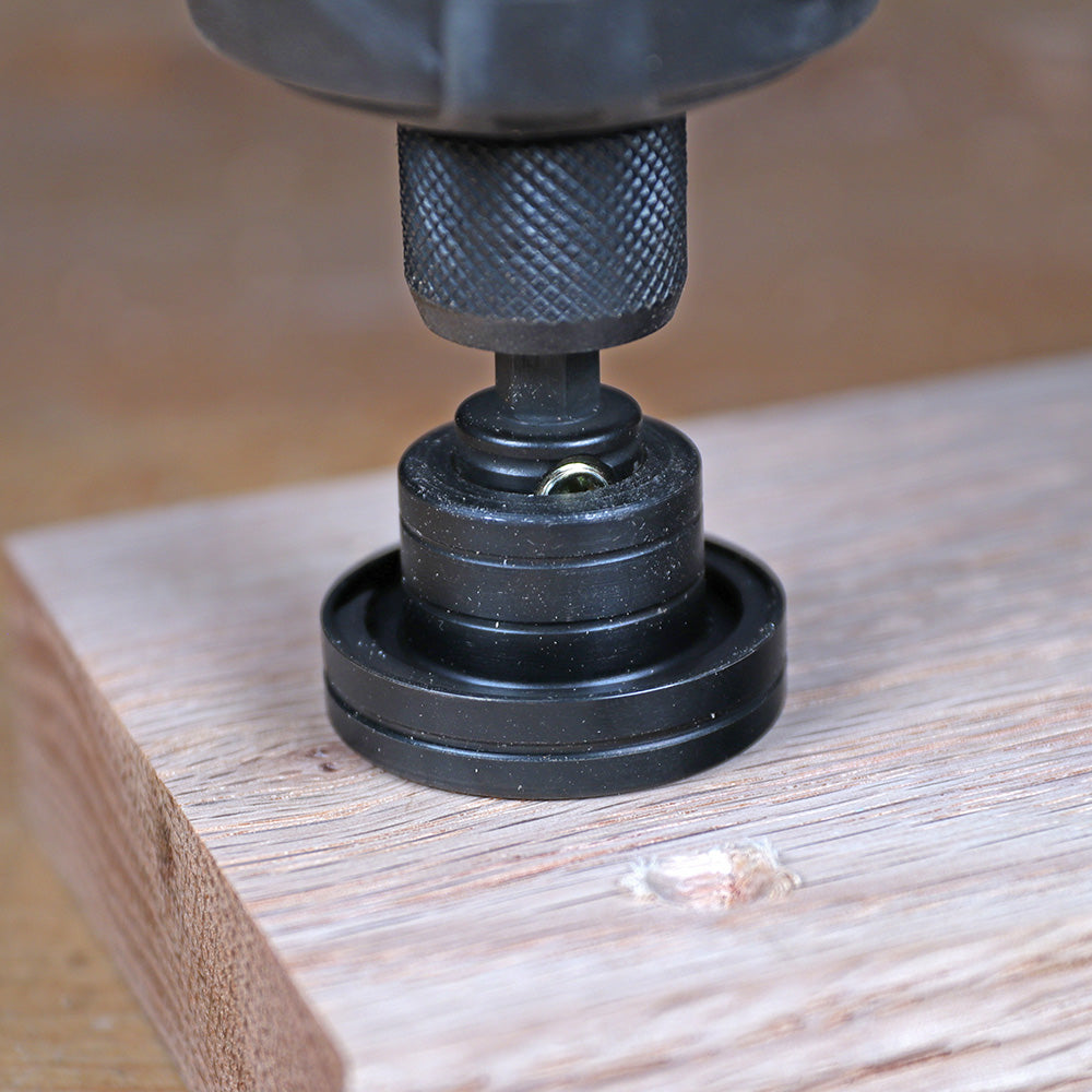Drill guide attachment positioned on a wooden board for precise woodworking drilling
