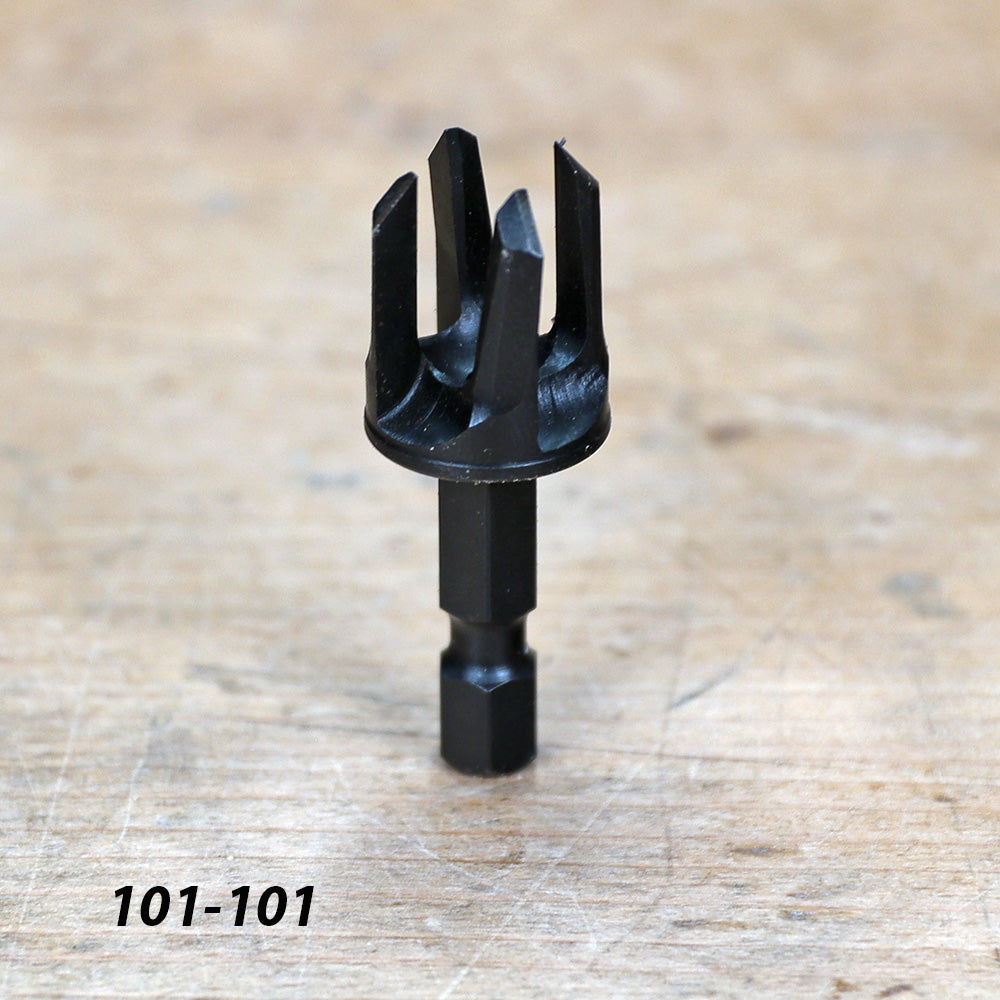 Black woodworking drill bit with hex shank on wood surface, product code 101-101.