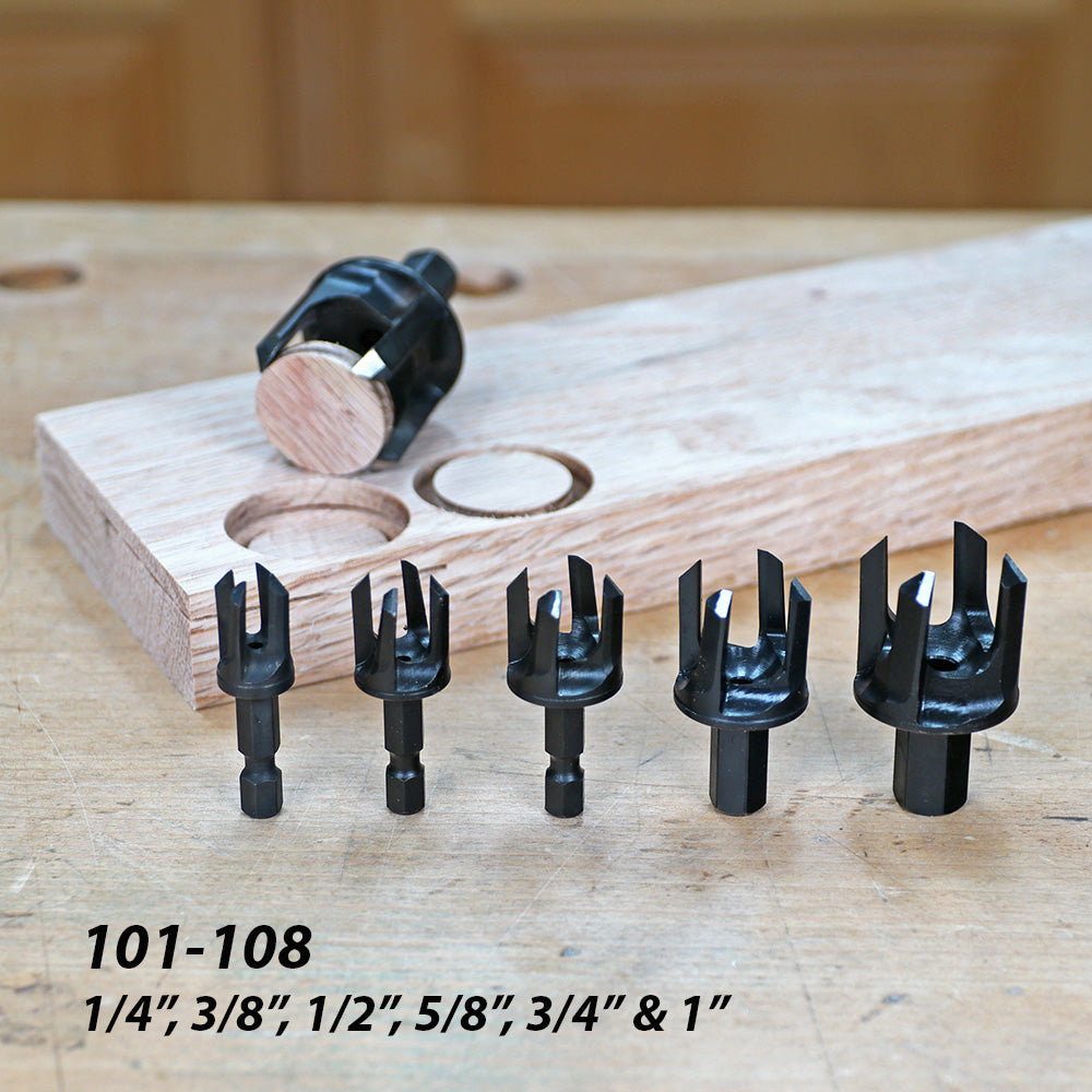 Six plug cutters in various sizes with wood plugs and drilled board on a woodworking bench