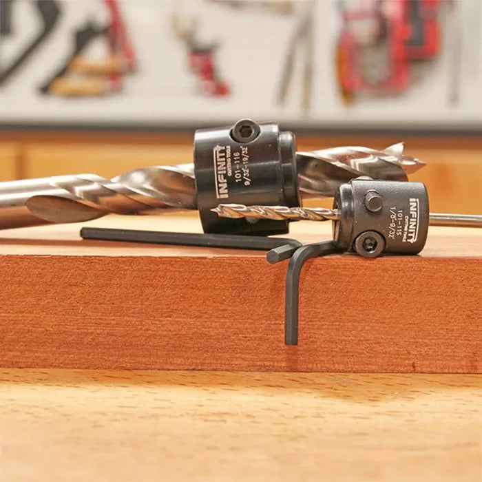 Woodworking drill bits with depth stop collars and hex key on a wooden board