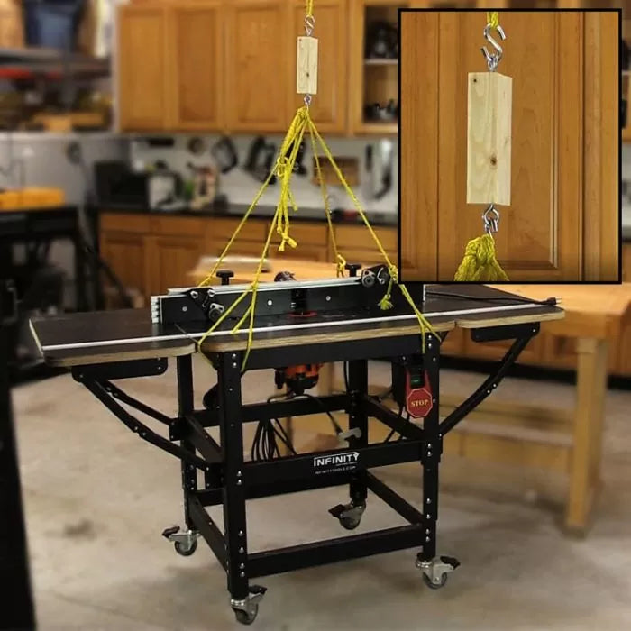 Router table lift system with yellow rope and wooden block in a woodworking shop setting.