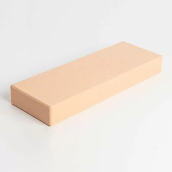 Beige rectangular sharpening stone for woodworking tools on a white background
