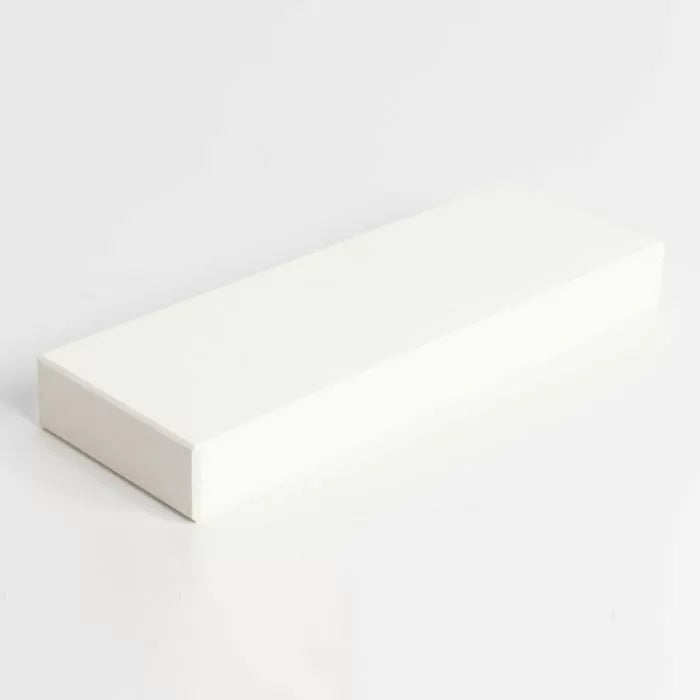 Rectangular white sharpening stone for woodworking tool maintenance on white background.