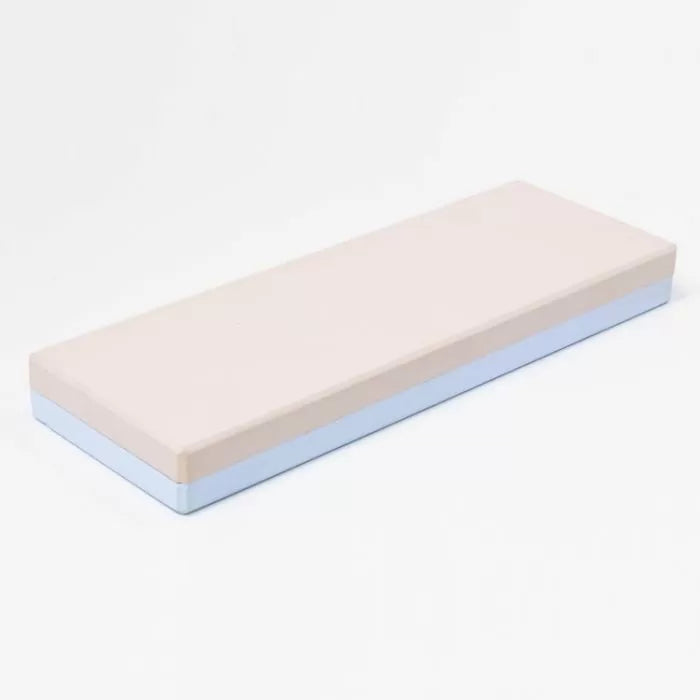 Double-sided sharpening stone with beige and blue layers on white background