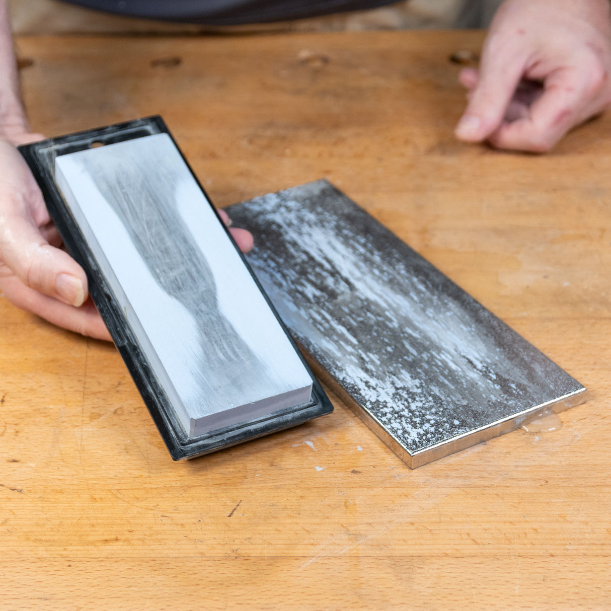 Sharpening stone and lapping plate on wooden workbench for woodworking tool maintenance