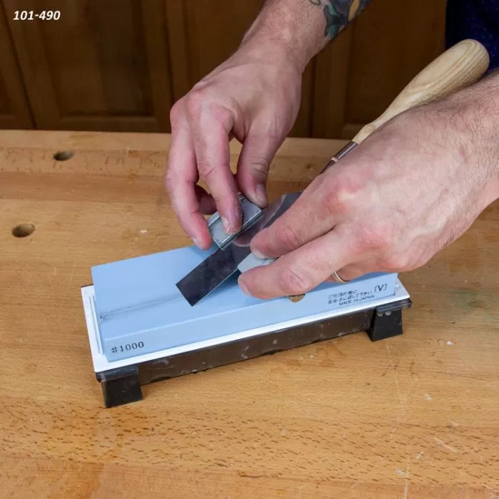 Sharpening a woodworking chisel on a #1000 grit water sharpening stone on a workbench