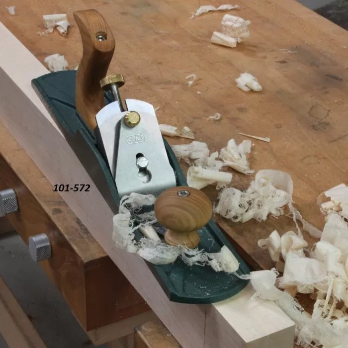 Woodworking hand plane on workbench with wood shavings and labeled 101-572