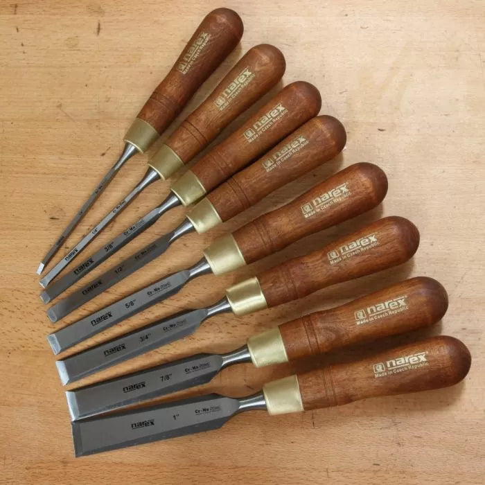 Set of seven woodworking chisels with wooden handles on a workbench