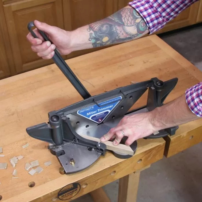 Manual miter trimmer in use on woodworking bench for precise wood angle cuts