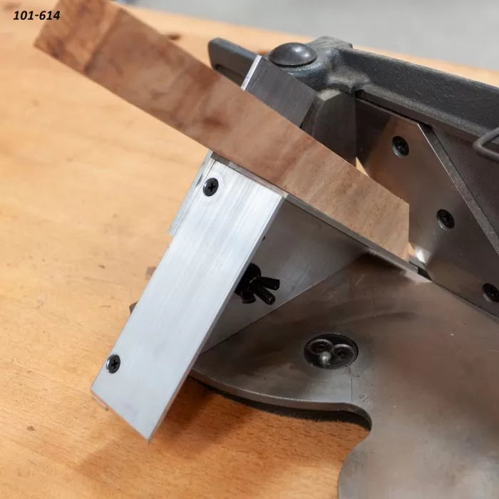 Woodworking miter jig holding angled wood strip on workbench for precise cutting