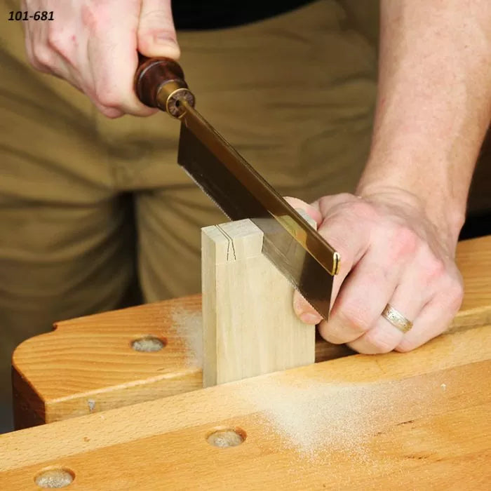 Woodworker using a dovetail saw to cut precise joints in wood on a workbench