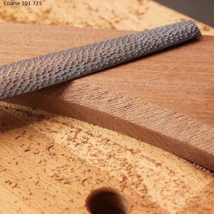 Coarse wood rasp file smoothing wood edge in woodworking workshop