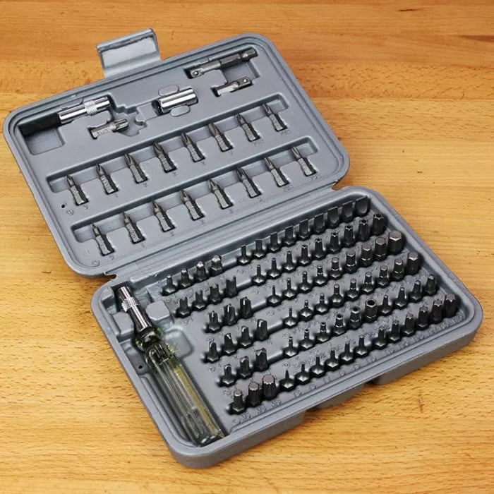 Precision screwdriver bit set in gray case on wooden workbench