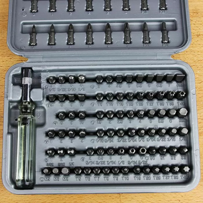 Precision screwdriver bit set with clear handle, assorted bits in plastic case on wood surface