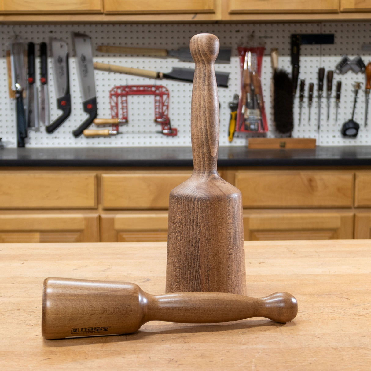 Wood carving mallets on workshop bench with woodworking tools in background