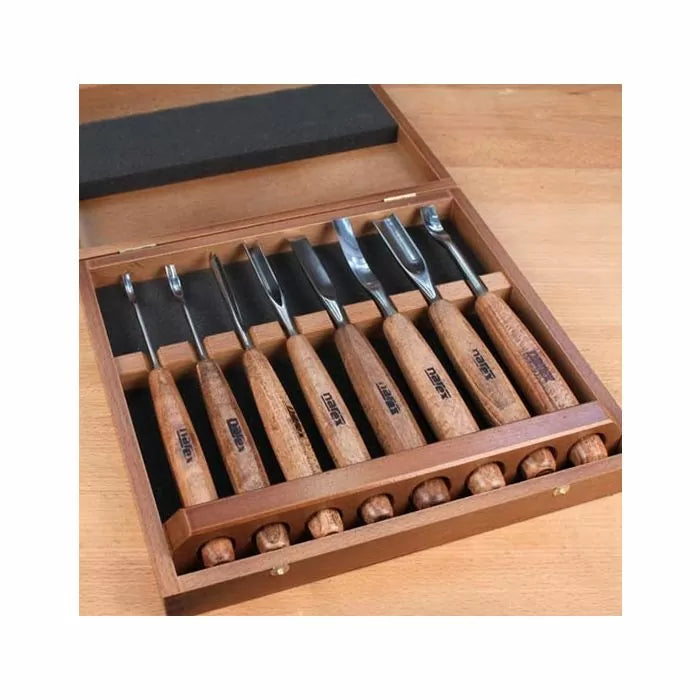 Wood carving chisel set with wooden handles in a display case on a wooden table