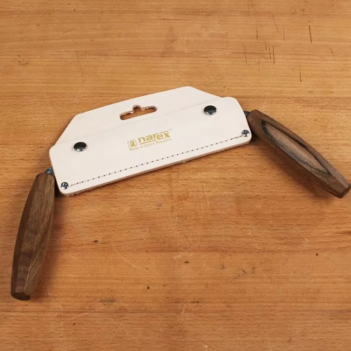 Narex woodworking drawknife with wooden handles and leather blade sheath on a workbench